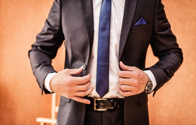 結婚式に向けてスーツを着て身だしなみを整える男性