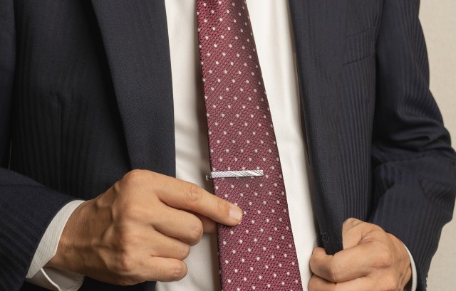 ネクタイピンをつける男性
