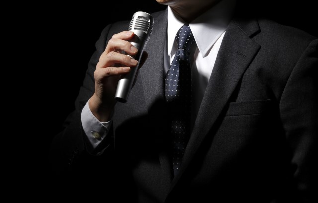 スーツ姿でスピーチをする男性