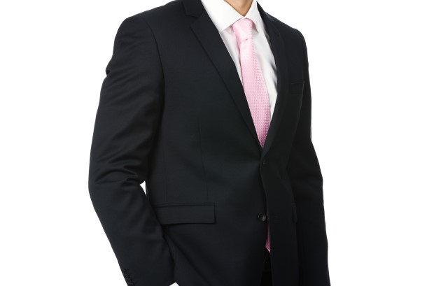 パステルピンクのネクタイを合わせたブラックスーツの男性