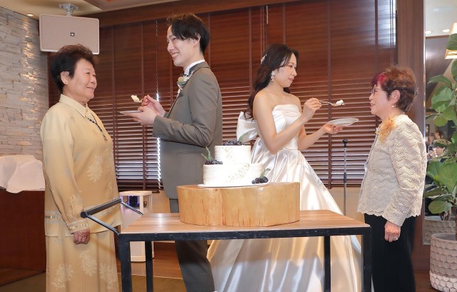 それぞれの祖母にケーキを食べさせる新郎新婦