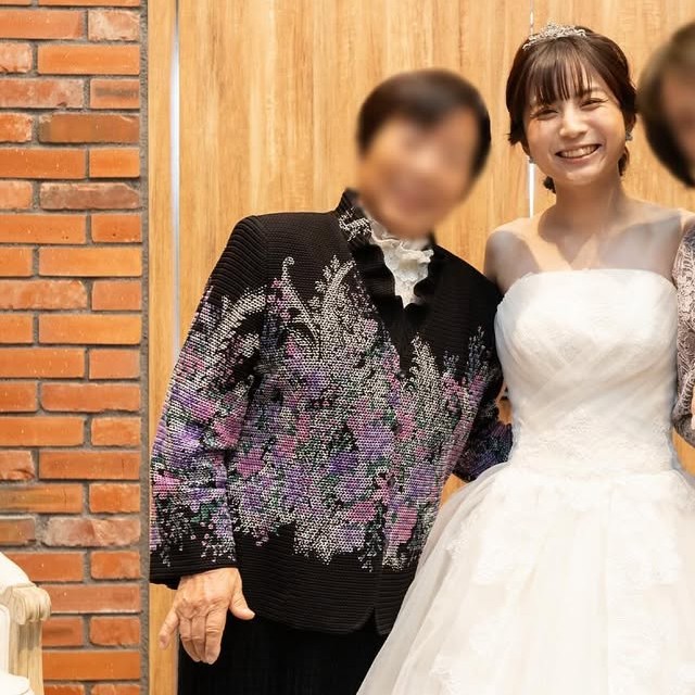 黒のアンサンブルを着た祖母と寄り添う新婦