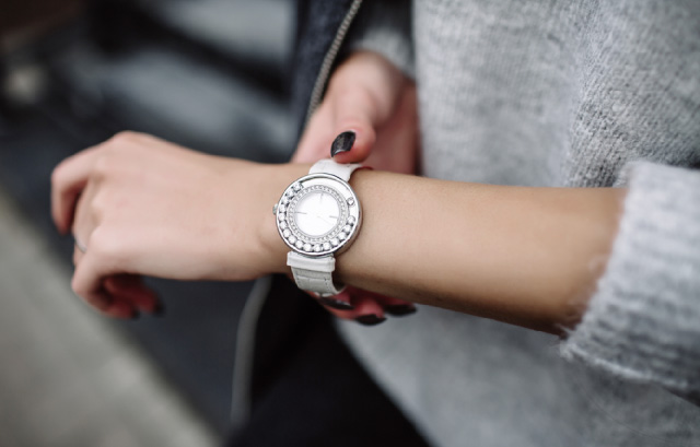 腕時計で時間を確認する女性