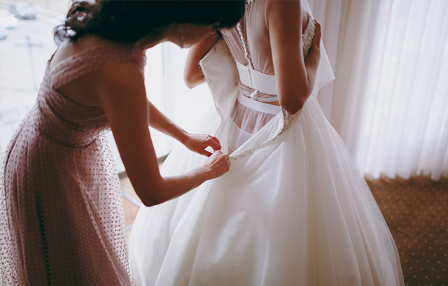 ドレスを着付けてもらう花嫁