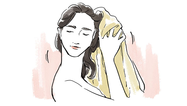 濡れた髪をタオルで拭く女性