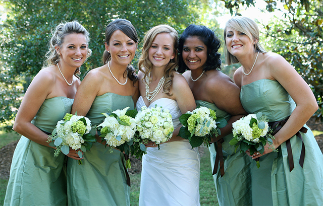 花嫁とグリーンのドレスを着たブライズメイドがボタニカルブーケを持つ様子