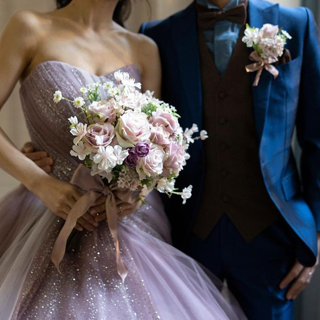 カラードレスの紫と合わせたバラを主役に、淡いカラーの桜