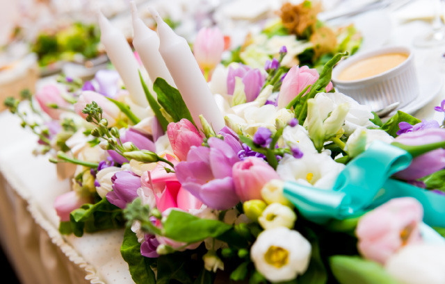 ピンクや紫のチューリップと白い花やグリーンが飾られたテーブル