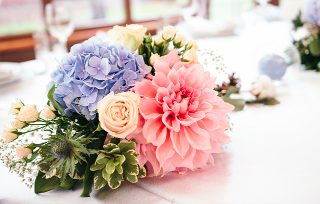 紫陽花やピンクのダリア、淡いピンクのバラが飾られたテーブル
