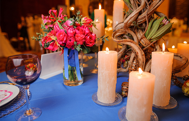 ブルーのクロスに濃いピンクの装花が飾られたテーブル