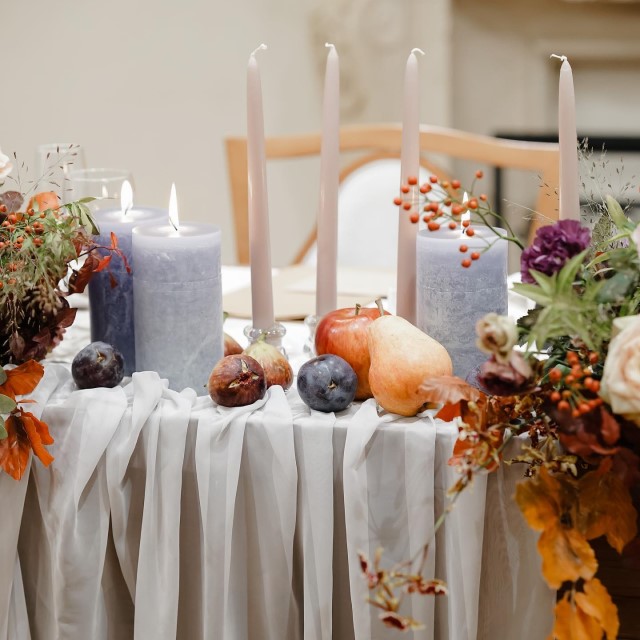 テーブルの上にろうそくとともに飾られたフルーツ