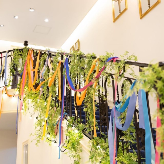 会場の階段の手すりにカラフルなリボンを巻いて垂らした様子