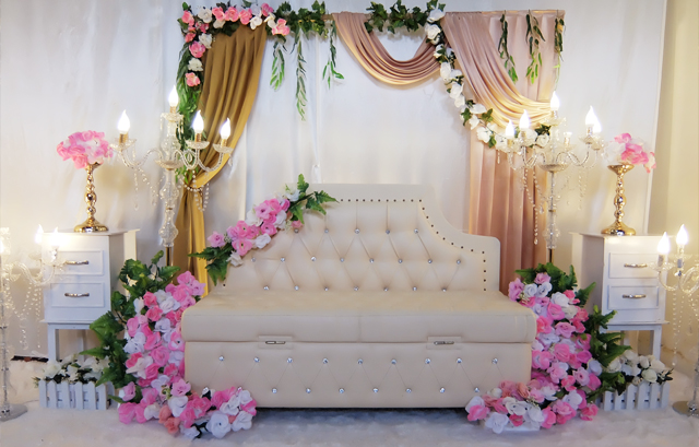 白いソファの両側にピンクと白の花を配置した高砂装花