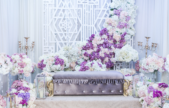天井から流れ落ちるように紫と白の花が飾られた高砂装花