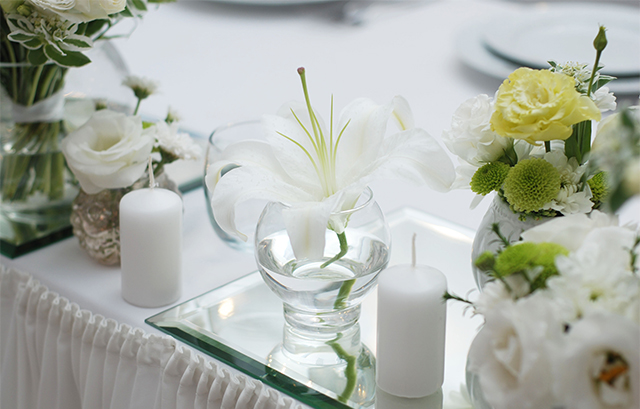 白のクロスがかけられたテーブルに白い花が飾られた様子