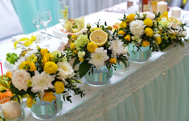 ビタミンカラーの花とレモンが飾られたメインテーブル