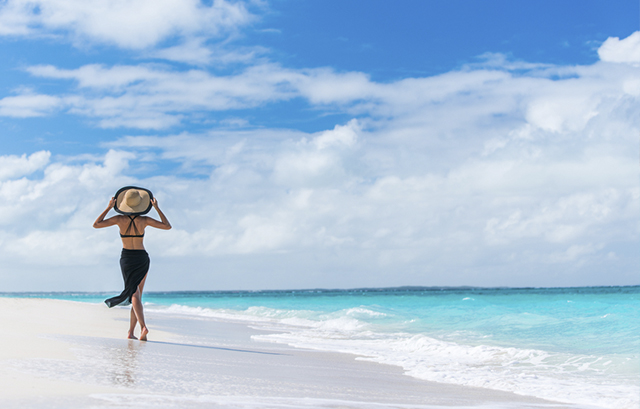 砂浜を歩く水着姿の女性
