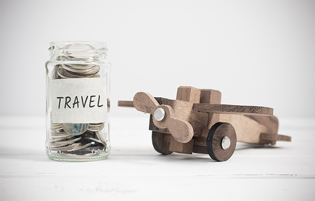 お金が入っている「TRAVEL」と書かれた瓶と木で作られた飛行機の玩具
